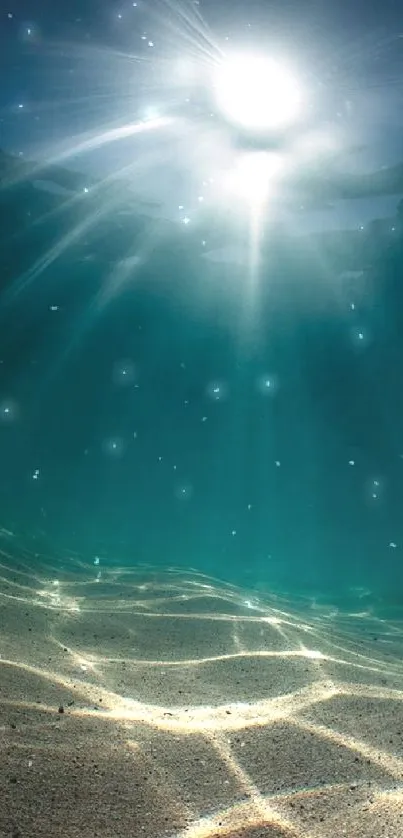 Underwater sunlight with sandy seabed and blue ocean.