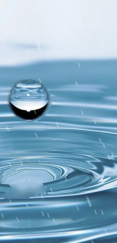 Serene blue water droplet creating ripples, reflecting tranquility.