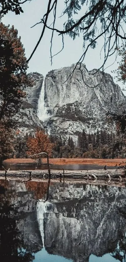 Waterfall cascading down a rocky mountain, reflecting in a tranquil lake.