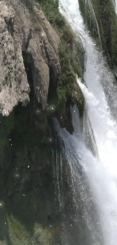 Cascading waterfall over rocky cliffs with lush greenery.