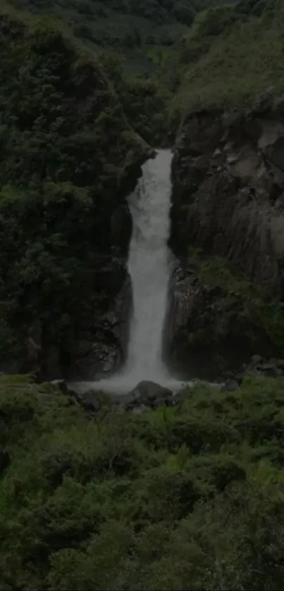 Lush green landscape with a tranquil waterfall cascading down rocks.