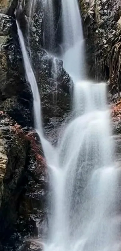 Serene waterfall cascading down rugged cliffs for a tranquil phone wallpaper.