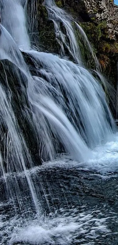 Serene waterfall with cascading waters and rocky landscape.