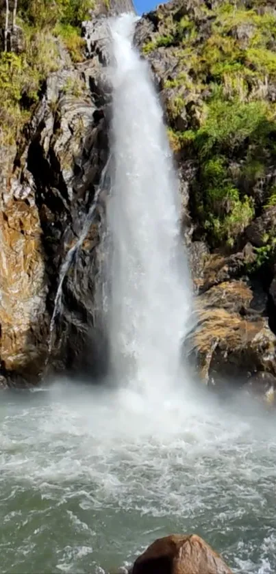 Peaceful waterfall amidst rocky scenery for mobile wallpaper.