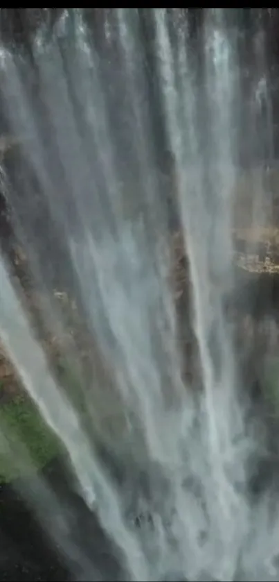 Serene waterfall cascading down rocks with lush greenery