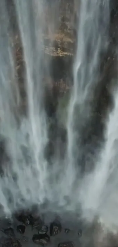 Waterfall cascading down rocks in a serene natural setting.