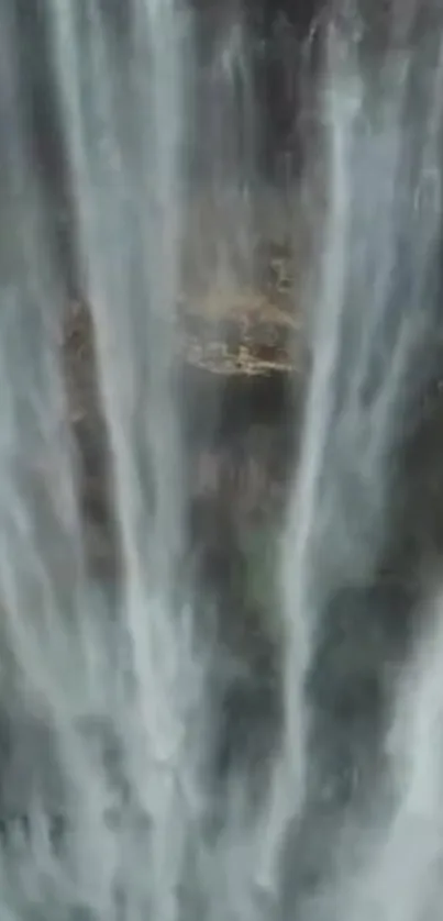 Cascading waterfall with lush green background.