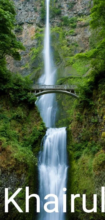 Serene waterfall with lush greenery and a bridge in the background.