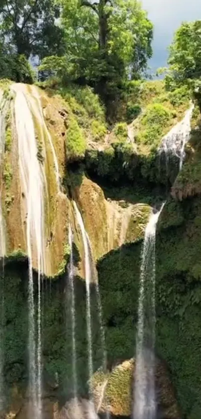 Vertical waterfall cascading over green cliffs.