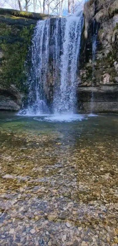 Serene waterfall flowing into clear pool of water.