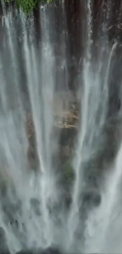 A tranquil waterfall cascading down rocky cliffs in lush greenery.