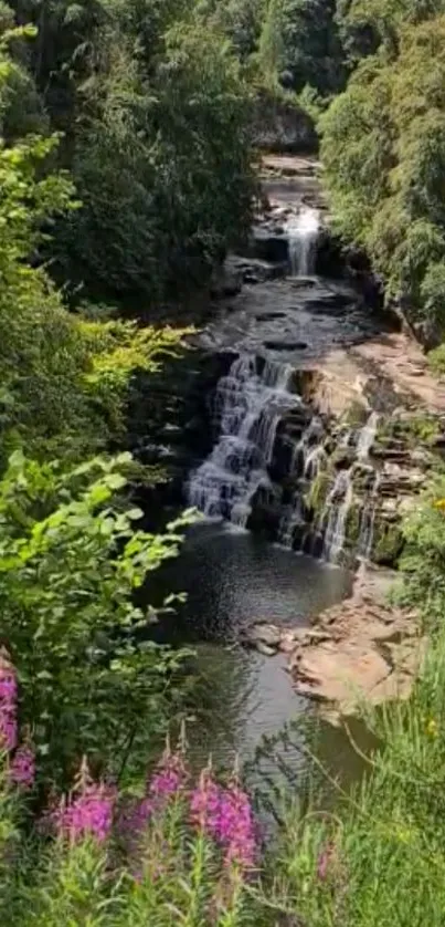 Scenic waterfall with lush greenery and vibrant pink flowers.