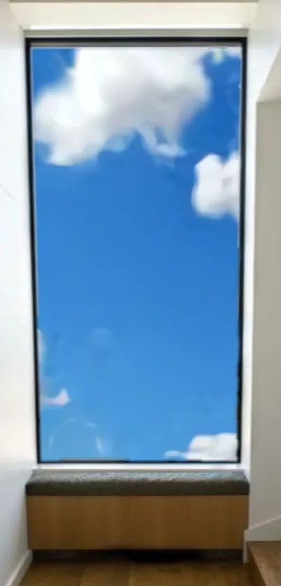 Serene blue sky with fluffy clouds viewed through a modern window.