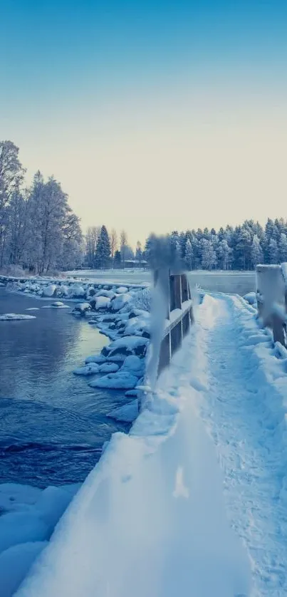 Snowy bridge crossing a serene icy river under a clear sky.