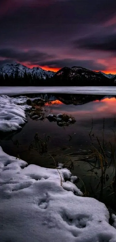 Winter sunset over mountains reflected in a serene lake.