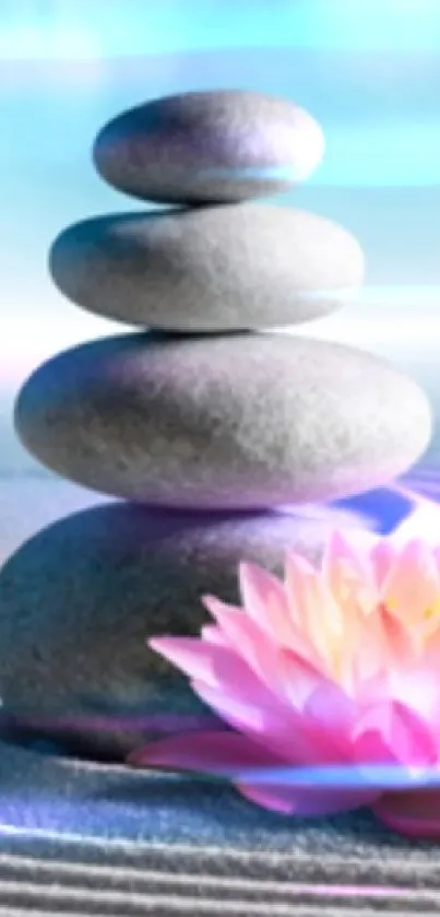 Zen stones and lotus flower in a serene sand garden with a blue sky background.