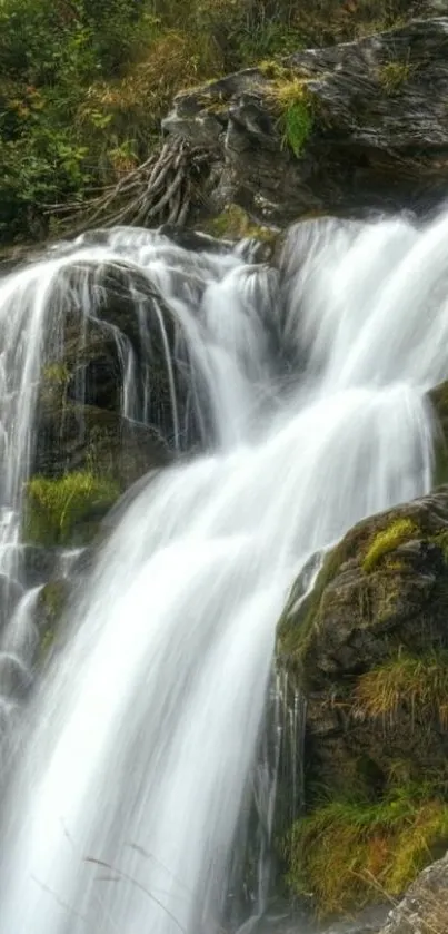 Cascading waterfall with lush greenery and rocky terrain in a serene landscape.