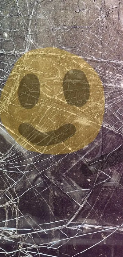 Shattered glass screen with a smiling emoji overlaid for a quirky artistic effect.