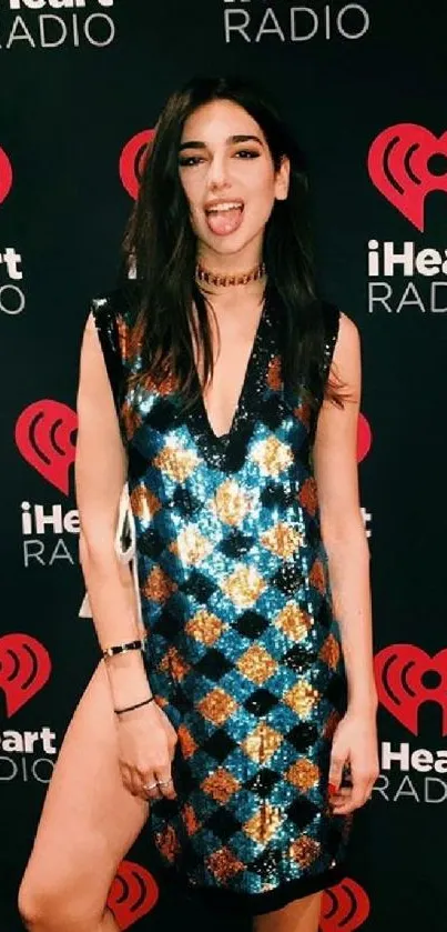 Fashionable woman at iHeartRadio event backdrop.