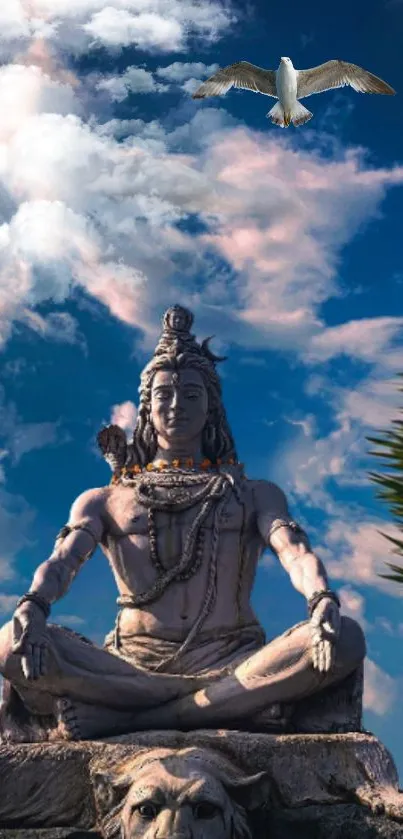 Statue of Shiva meditating under a blue sky.