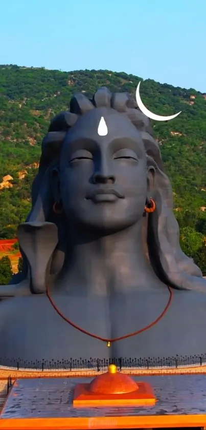 Majestic Shiva statue with green hills in the background.