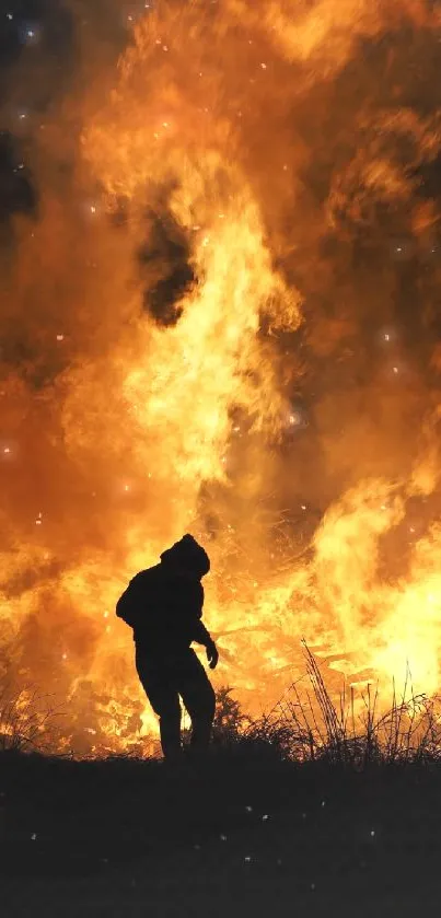 Silhouette standing against a large fire, creating a dramatic night scene.