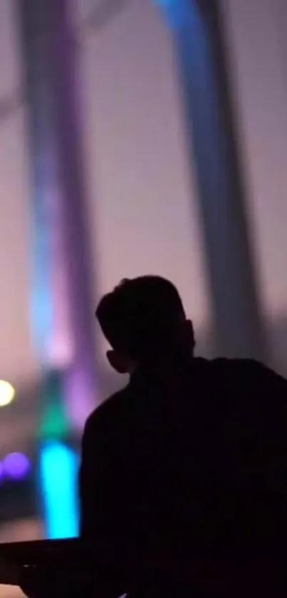 Silhouette of a person against a purple neon cityscape at night.