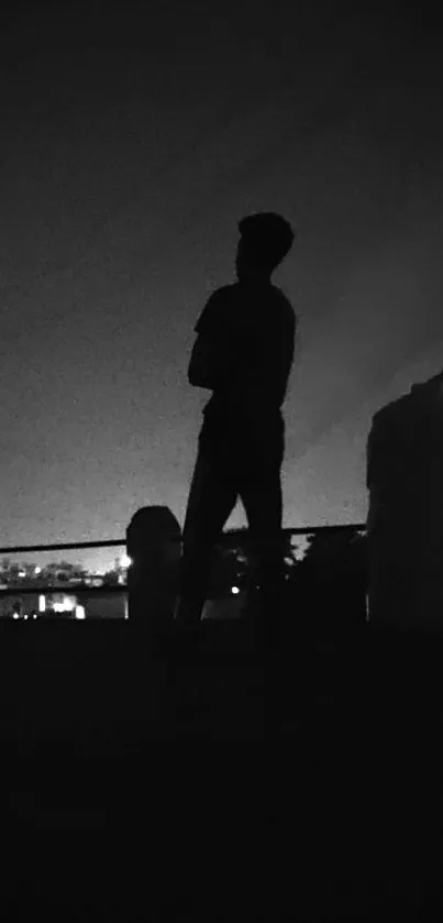 Silhouette of a person against a night sky on a rooftop.