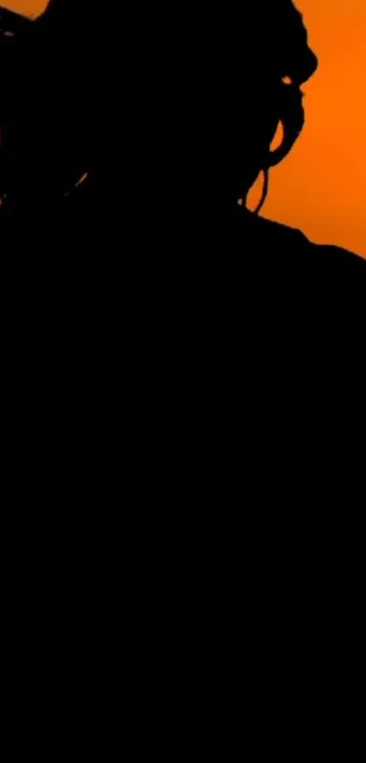 Black silhouette against bright orange sunset background.