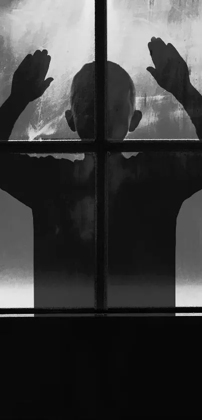 Silhouette of a person behind a foggy window in black and white.