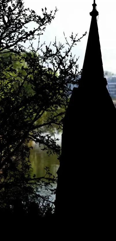 Mobile wallpaper of a silhouetted tower by a lakeside, surrounded by trees.