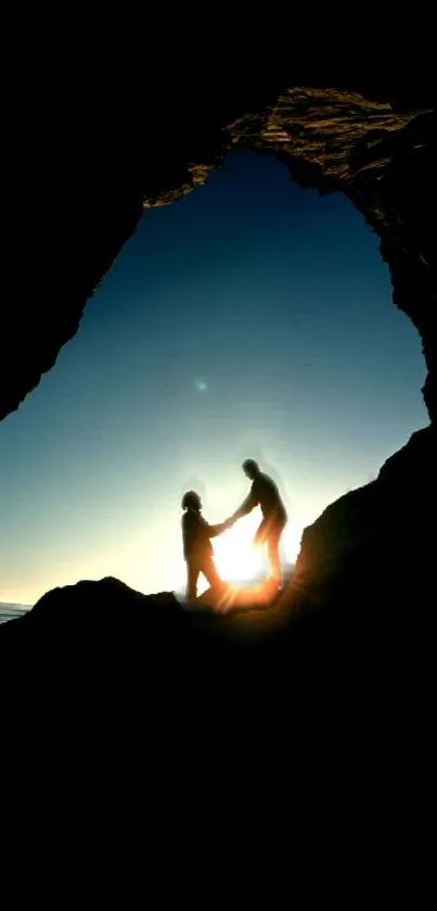 Silhouette of two figures in a cave at sunset over the ocean.