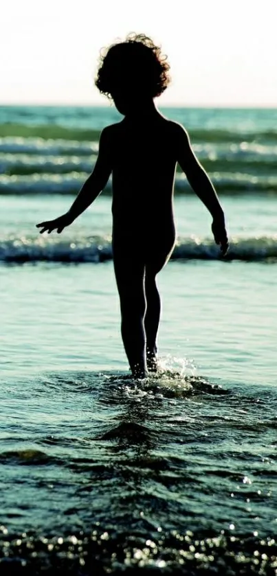 Silhouette of a child walking on the beach at sunset.