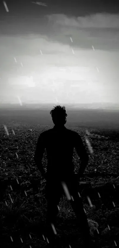 Silhouette of man overlooking city in black and white.