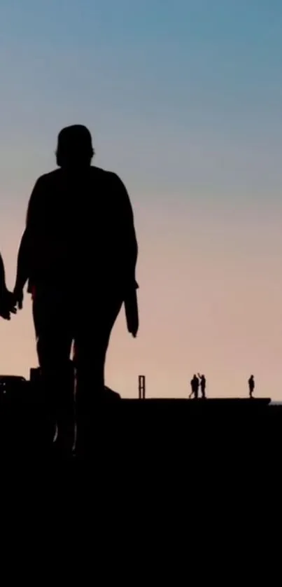 Silhouette of a couple walking hand in hand against an evening sky.