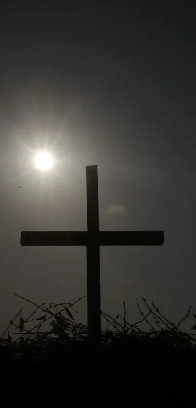 Silhouette of a cross against a sunrise sky.