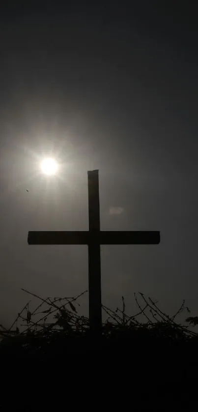 Silhouette of a cross against a sunset sky.