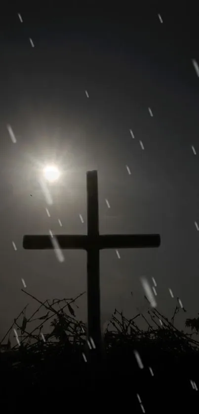 Silhouette of a cross with sunlight and raindrops in the background.