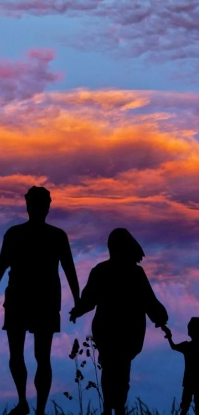 Family silhouette against a vibrant sunset sky with orange clouds.