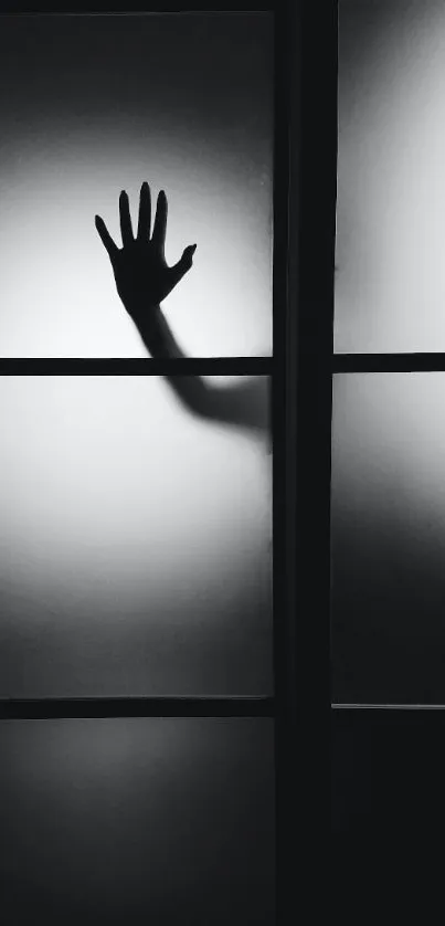 Silhouette of a hand against frosted glass creates a mysterious mobile wallpaper.