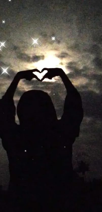 Silhouette forming heart under moonlit sky.