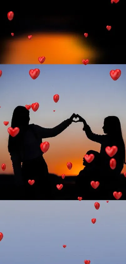 Silhouetted figures creating a heart with red hearts at sunset.