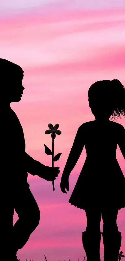 Silhouette of children with a flower against a pink sunset background.