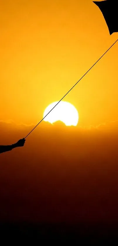 A silhouette of a person flying a kite against a vibrant orange sunset.