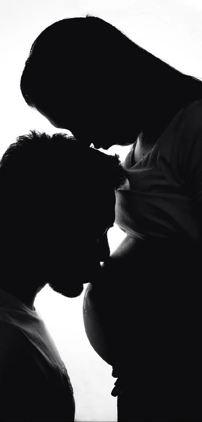 Black and white silhouette of expecting parents showcasing love and anticipation.