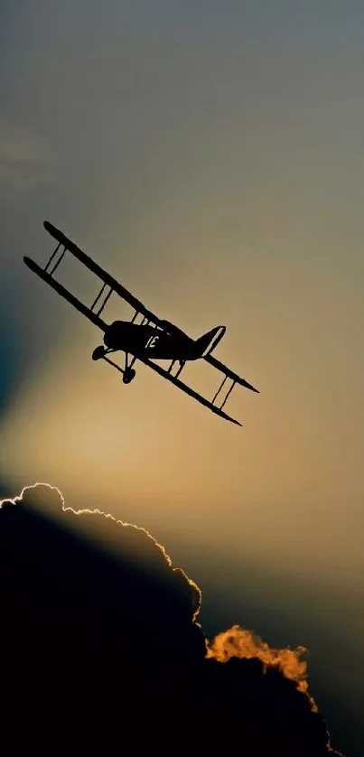 Silhouette of a biplane against sunset clouds.