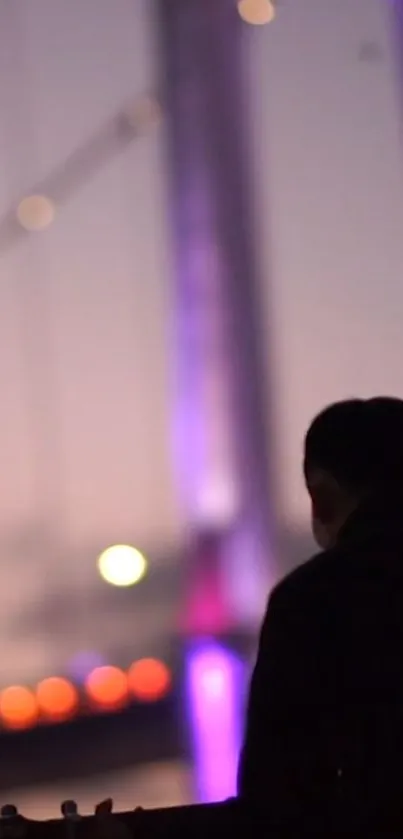 Silhouette of a person against a colorful bridge and evening sky.