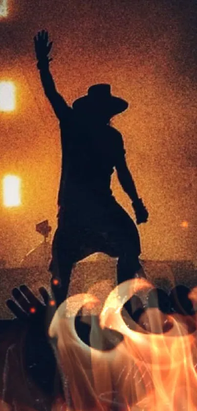 Silhouette of a performer on stage with vibrant orange lights.