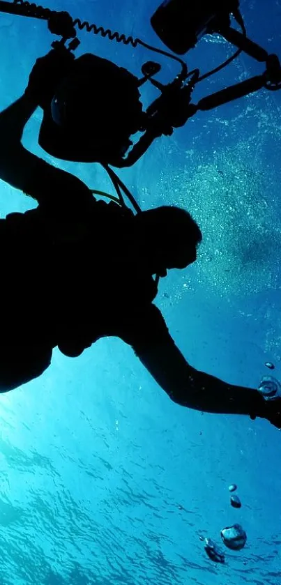 Silhouette of scuba diver against a blue ocean background with bubbles.