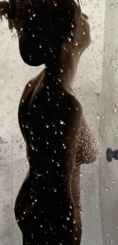 Silhouette of a person in a shower with water droplets on glass.